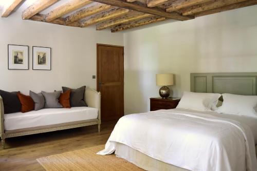 a bedroom with a white bed and a couch at Château de Chavigny in Chambourg-sur-Indre