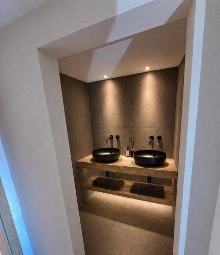 a bathroom with two sinks on a wall at Kapitel 7 Boutique-Hotel in Raron