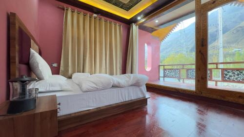 a bedroom with a bed in a room with windows at Pahadon Ka Ghar in Sonāmarg