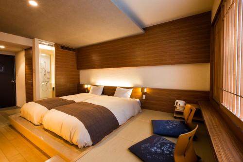 a bedroom with a large bed and a chair at Choyo Tei in Kamikawa