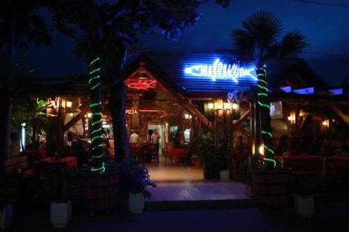 ソゾポルにあるApartments Kaloyanの夜に外に座る人々と照らす看板のあるレストランです。