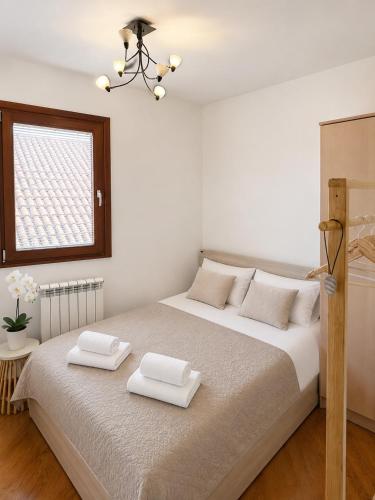 a bedroom with a large bed with two towels on it at SPLENDID Sunset Penthouse in Rafailovici