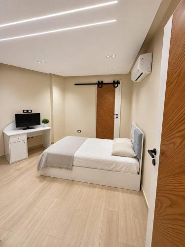 a bedroom with a bed and a desk and a television at Cyra gate Suncapital compound شقة في كامبواند صنكابيتال بوابة كايرا بالقرب in ‘Ezbet `Abd el-Ḥamîd