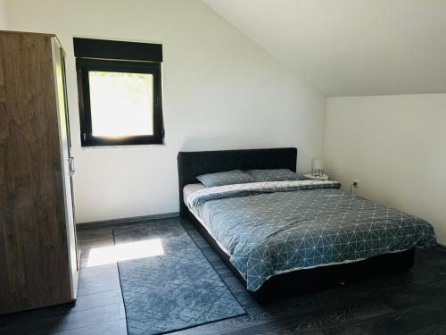 a bedroom with a bed and a window at Lux apartmani in Bihać