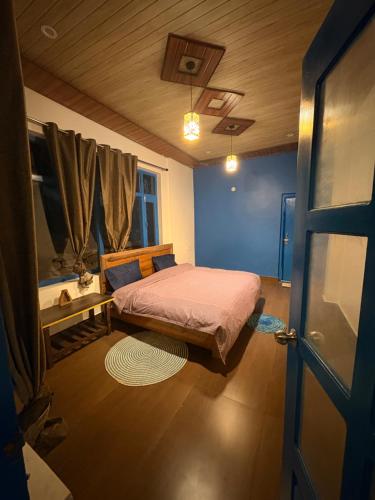 a small bedroom with a bed and a door at Tree house munsyari in Munsyari