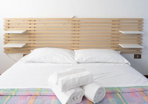 a white bed with two towels on it at Enza House in Chioggia