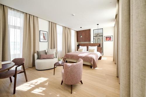 ein Hotelzimmer mit einem Bett und einem Stuhl in der Unterkunft Hôtel Éole Resort - Mons - Shape - Pairi Daiza in Warchaix