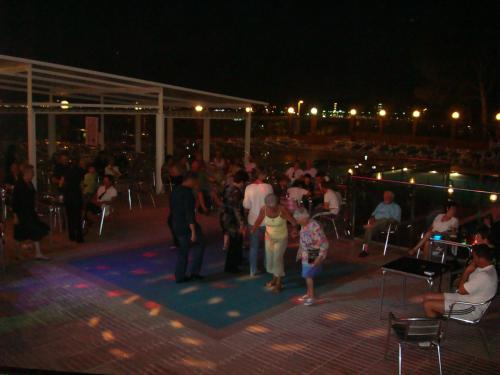 a crowd of people standing around at night at Hotel Univers in Roses