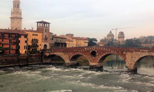 a bridge over a river in a city at Florivana Boutique Hotel in San Pietro in Cariano