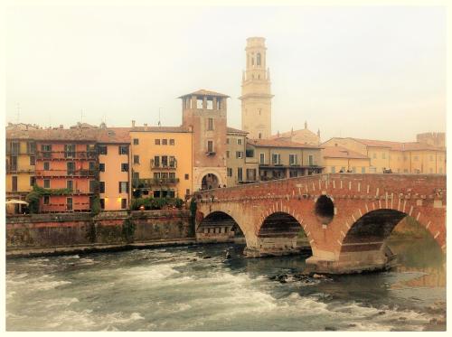 a bridge over a river in a city with buildings at Florivana Boutique Hotel in San Pietro in Cariano