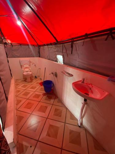 a red tent with a sink and a toilet at Stone Rose Vista in Kanatal
