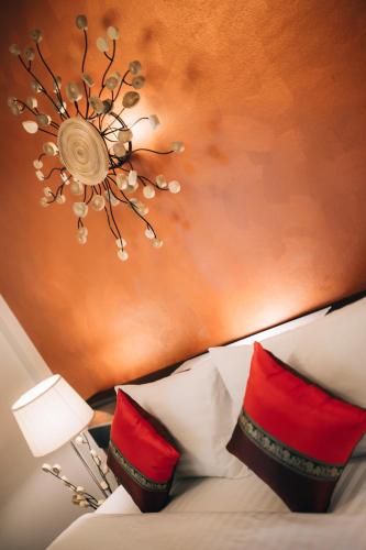 a chandelier hanging over a bed with red pillows at i Lanna House in Chiang Mai
