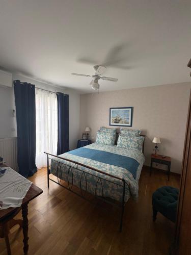 a bedroom with a bed with a blue comforter at Villa Les Hortensias B&B in Arcangues