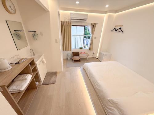 a white bedroom with a bed and a sink at RShotel in Tokyo