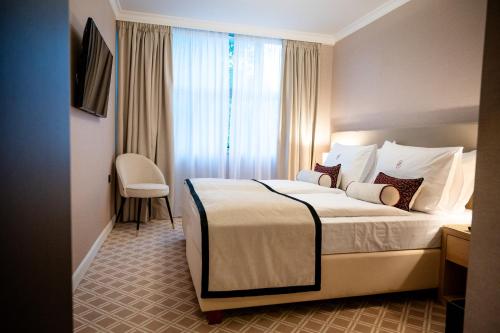 a hotel room with a bed and a chair at Hotel Park in Široki Brijeg