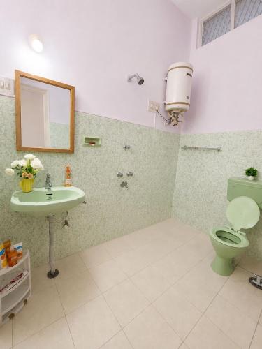 a bathroom with a green toilet and a sink at Clean Culture Retreat in Mysore