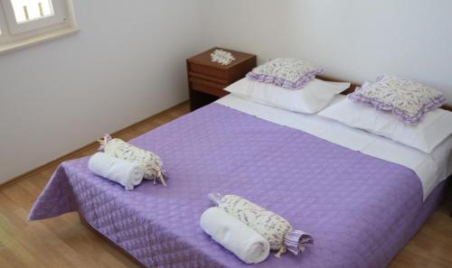 una camera da letto con un letto viola e asciugamani di Beautifull sea view apartment a Baška Voda