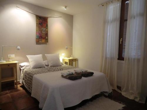 Schlafzimmer mit einem Bett mit weißer Bettwäsche und einem Fenster in der Unterkunft Namaste in Grazalema