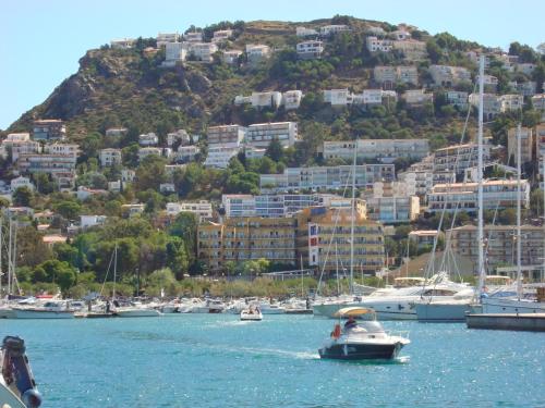 a group of boats in a harbor with a hill at Hotel Univers in Roses