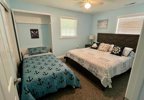 a bedroom with two beds and a ceiling fan at Dockside Dreamz 2 with beach & dock in Clarksville