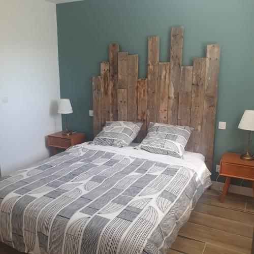 a bedroom with a large bed with a wooden headboard at La forge in Hinx