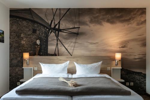 a bedroom with a large bed with a painting on the wall at Hotel in der Mühle in Werdau