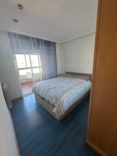 a bedroom with a bed in a room with a window at Apartamento Bamuxela in Vigo