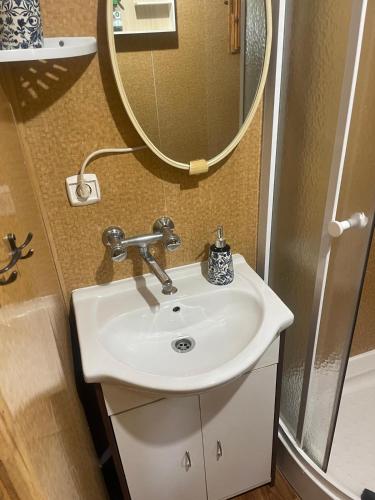 a bathroom with a sink and a mirror at Merylula - Domek nad jeziorem in Przydwórz