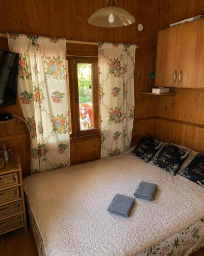 a bedroom with a bed with two towels on it at Merylula - Domek nad jeziorem in Przydwórz