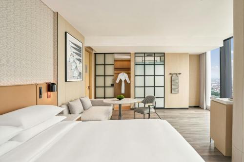 a hotel room with a bed and a living room at Sheraton Vinh in Yên Thinh (1)