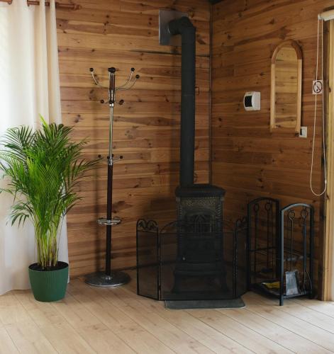 a fireplace in a room with a wooden wall at Domek U Stefanów - Królowy Most in Królowy Most