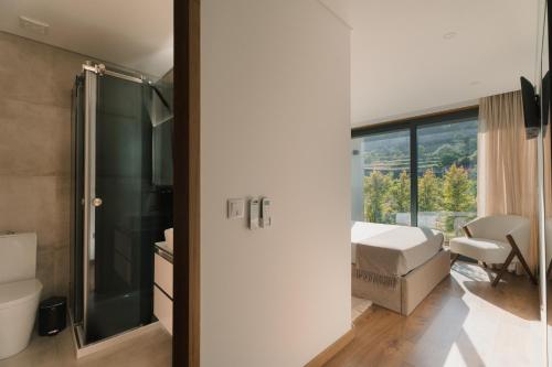 a bathroom with a bed and a shower and a window at Souto Village - Douro Verde - by FERO in Maureles