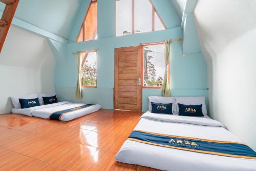 two beds in a room with blue walls and windows at The Cabin Artana By ARBA in Palayangan