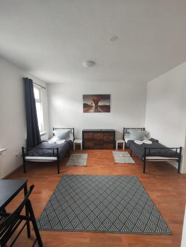a living room with two beds and a rug at Revant Monteurzimmer Haus WE 3 in Arnstadt