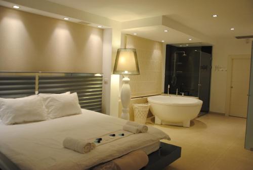 a bedroom with a large bed and a bath tub at Villa Riviera Eilat in Eilat