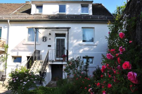 a white house with flowers in front of it at Ferienhaus Rosengarten Mürlenbach in Mürlenbach