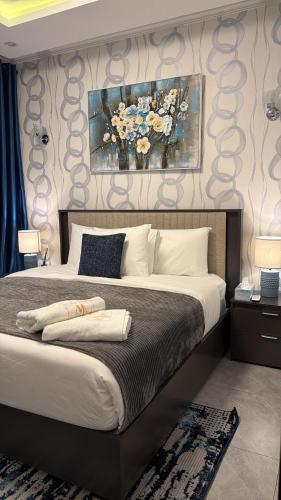 ein Schlafzimmer mit einem großen Bett und einem Gemälde an der Wand in der Unterkunft Empire M in Kinshasa