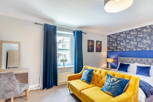 a bedroom with a bed and a yellow couch at The Haven, Leyburn in Leyburn