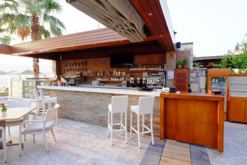 an outdoor bar with white chairs and a counter at Marisol Boutique Hotel in Gundogan