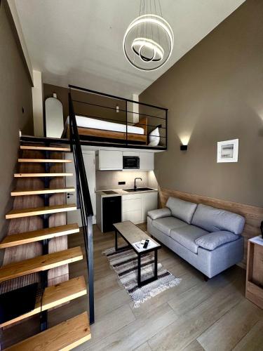 a living room with a staircase and a couch at Loft 73 in Kalamata