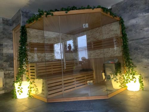 a room with a large glass enclosure with plants at Várfal Panzió és Wellness in Pécs