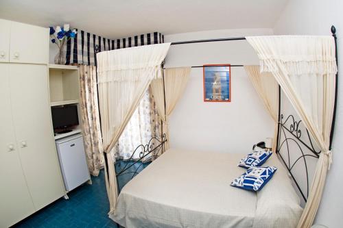 małą sypialnię z łóżkiem z baldachimem w obiekcie Hotel Ristorante Meson Feliz w mieście Terracina
