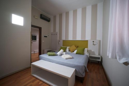 a bedroom with a bed with green and yellow pillows at Hotel Sant'Elia in Messina