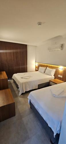 a hotel room with two beds and two tables at On Hotel in Adrasan