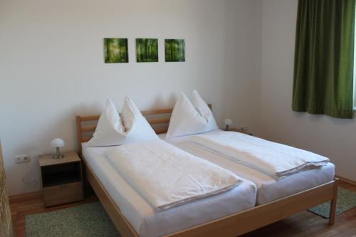 - une chambre avec 2 lits et des draps blancs dans l'établissement Ferienhaus Feichtinger, à Obertiefenbach