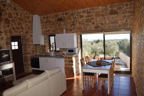 a kitchen and living room with a table and chairs at Casa do Canto in Casais dos Monizes