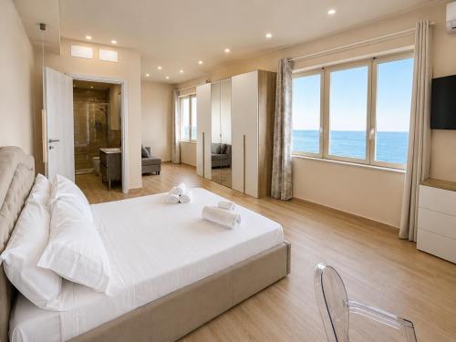 a bedroom with a white bed and a view of the ocean at AWA Kafara in Porticello