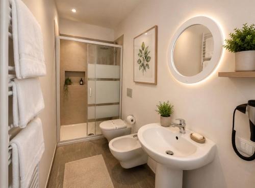 a bathroom with a sink and a toilet and a mirror at VILLA CHIARA Lago Maggiore in Gravellona Toce