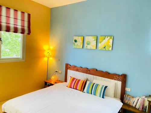 a bedroom with a bed and a blue wall at Mei Shiou B&B in Dongshan