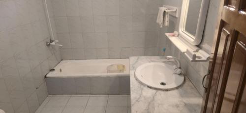 a bathroom with a bath tub and a sink at Basera Lodges in Nathia Gali